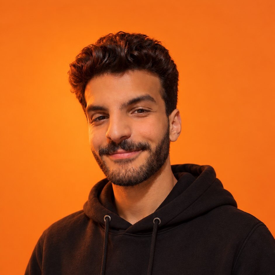 Yehia Zakaria, performance marketing expert and media buyer, smiling in a black hoodie against an orange background